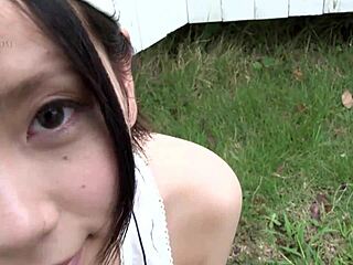 A stunning Asian girl with a pixie cut showcases a baseball bat on her breasts