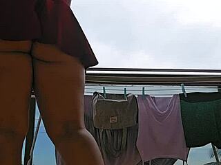 Naughty maid flashes big ass under skirt on balcony