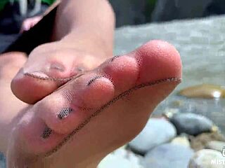 Goddess in tan nylons show her cute nylon soles and toes on the riverside