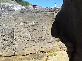 On the sunny beach, an African nudist prostitute flaunts her firm ass while teasing passersby seductively.